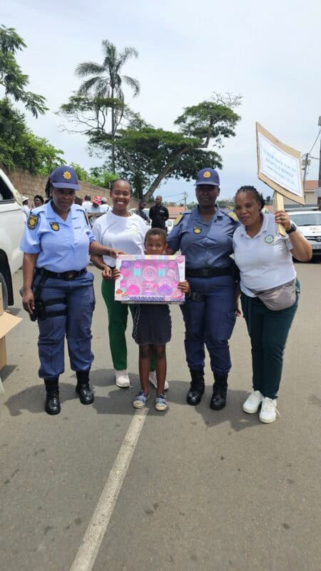 Two police officers, two women and a child holding a poster.