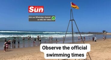 A wide-angle photo of people swimming at Amanzimtoti main Beach.