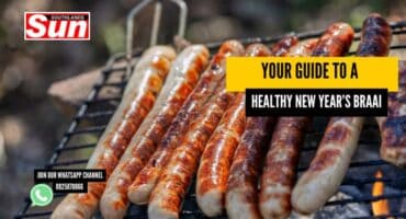 Sausages cooking on a braai stand.