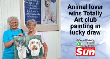 Two women with a painting of a cat and dog