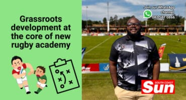 A rugby coach in front of a rugby field