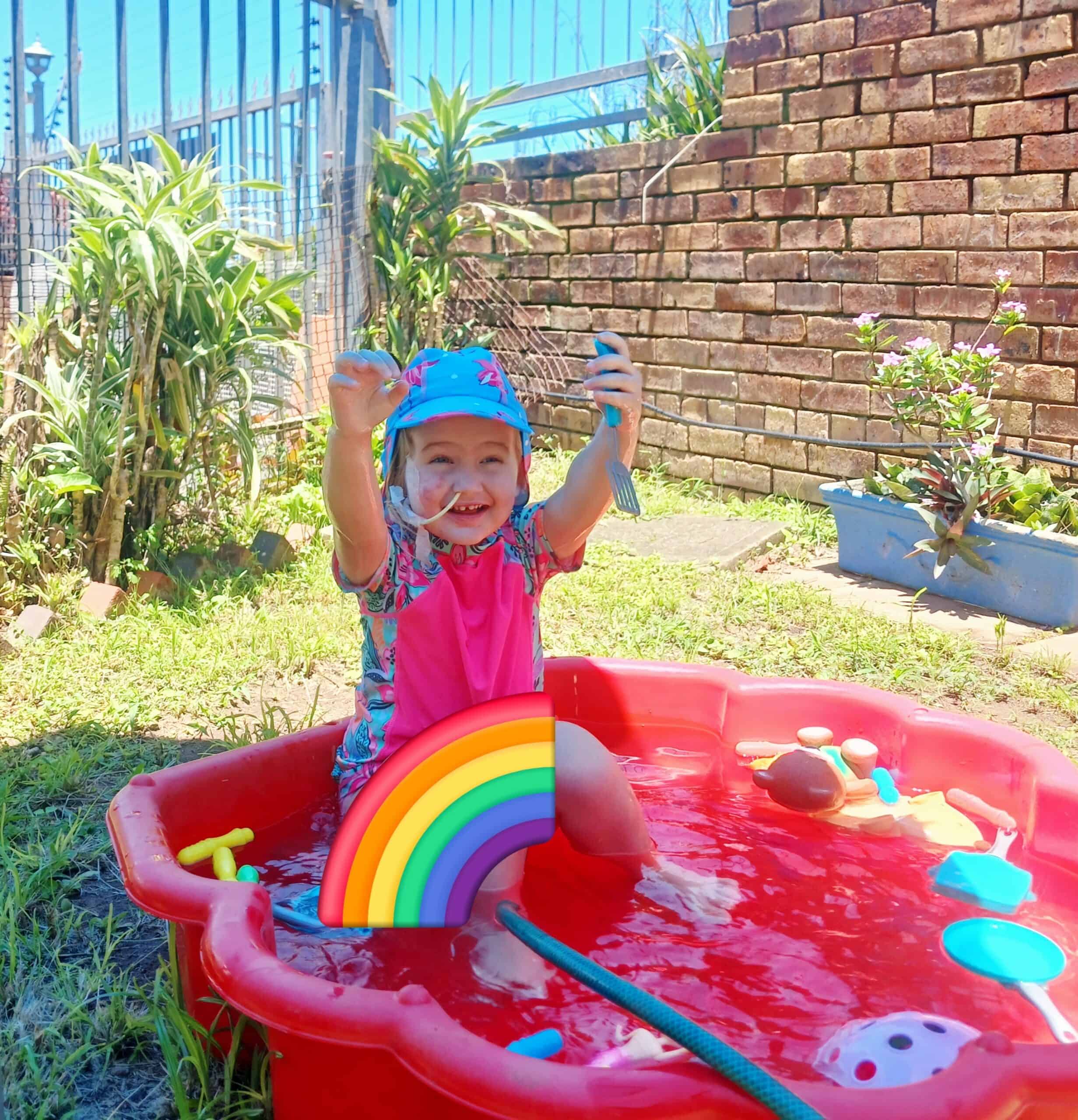 A toddler playing in a kiddie pool