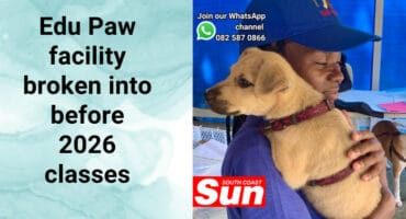 A woman carrying a puppy over her shoulder.