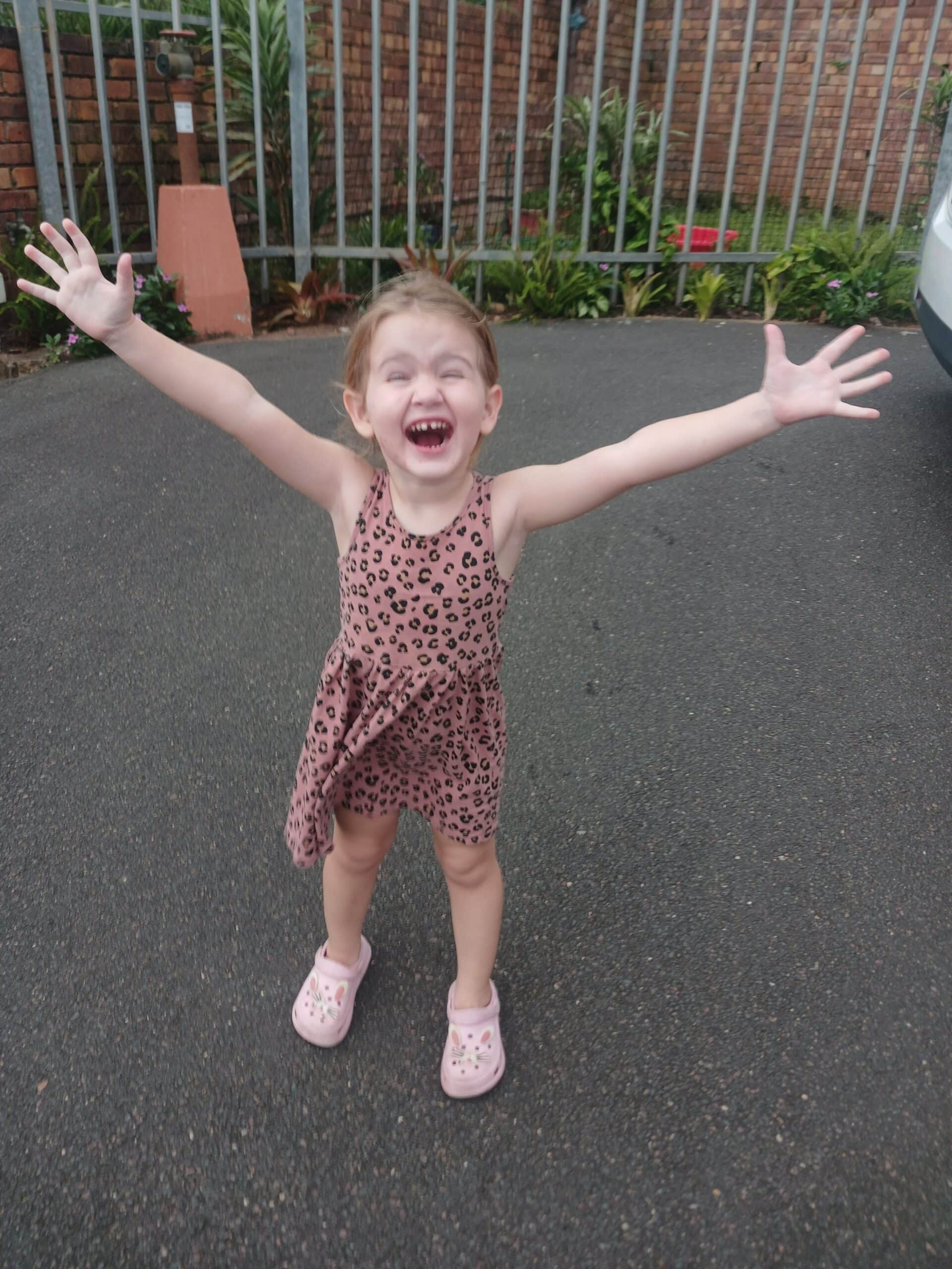 A toddler with her arms wide open