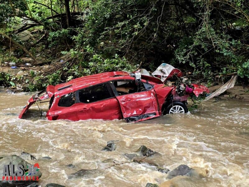 A photo of a wrecked car in a river.