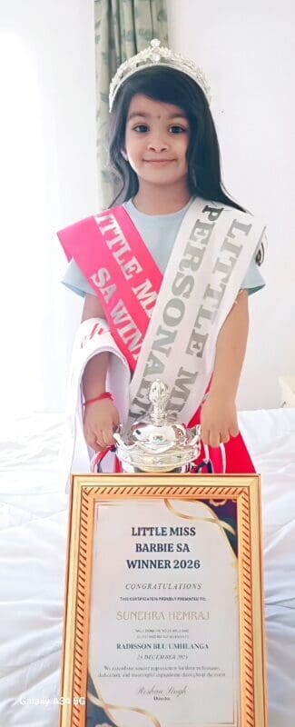 A girl with two sashes, an award and a trophy
