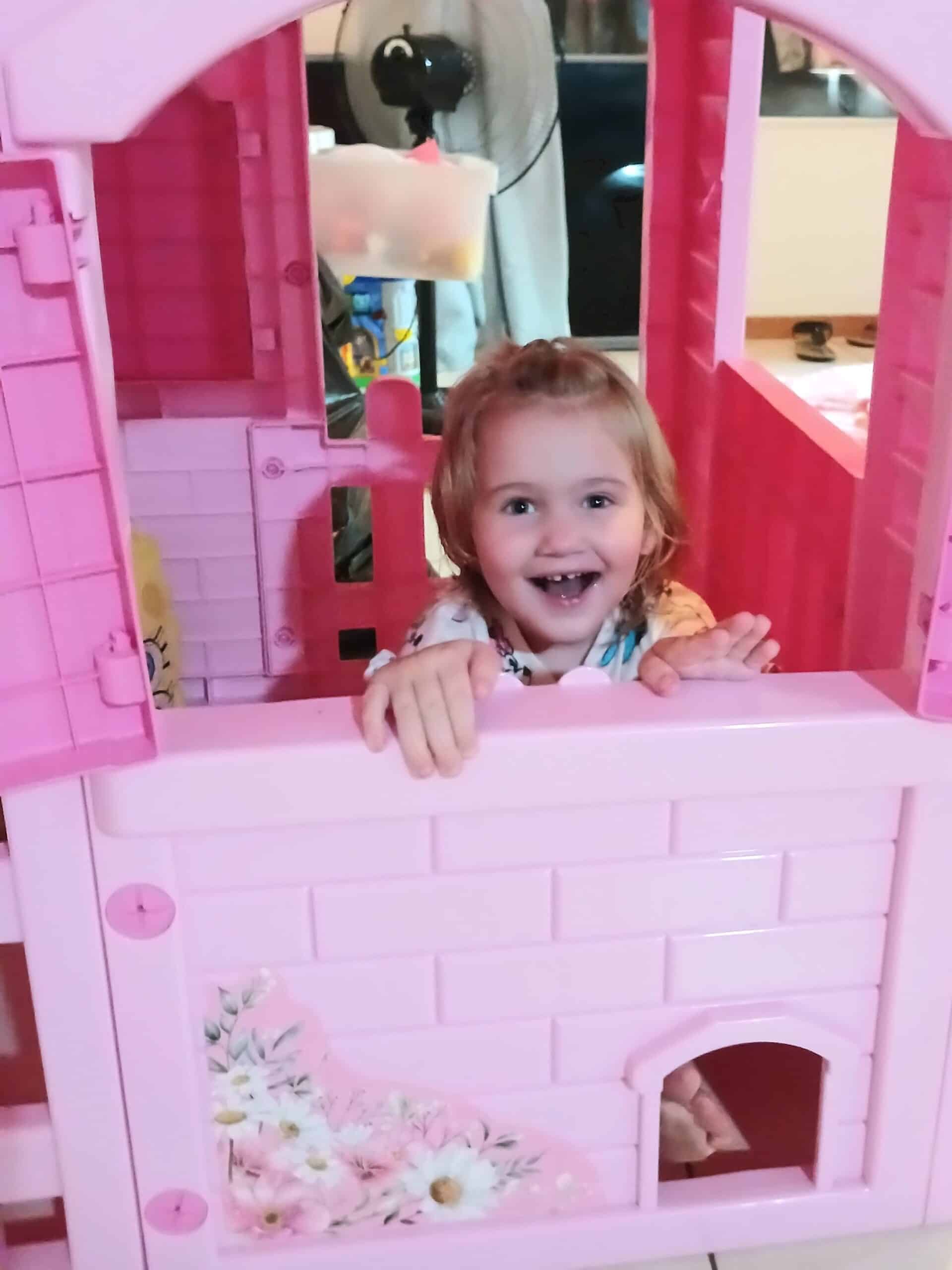 a toddler playing in a dollhouse
