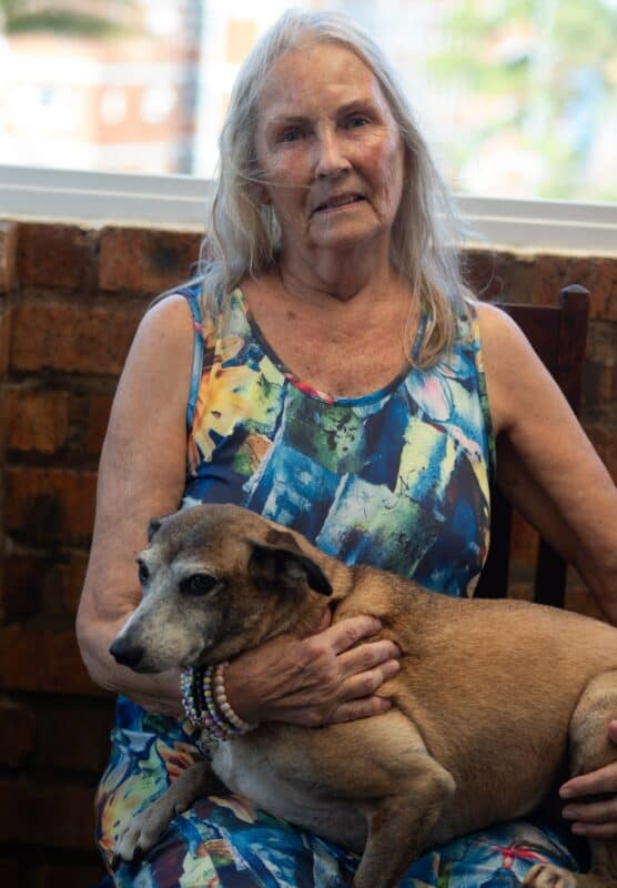 an elderly woman holding a dog