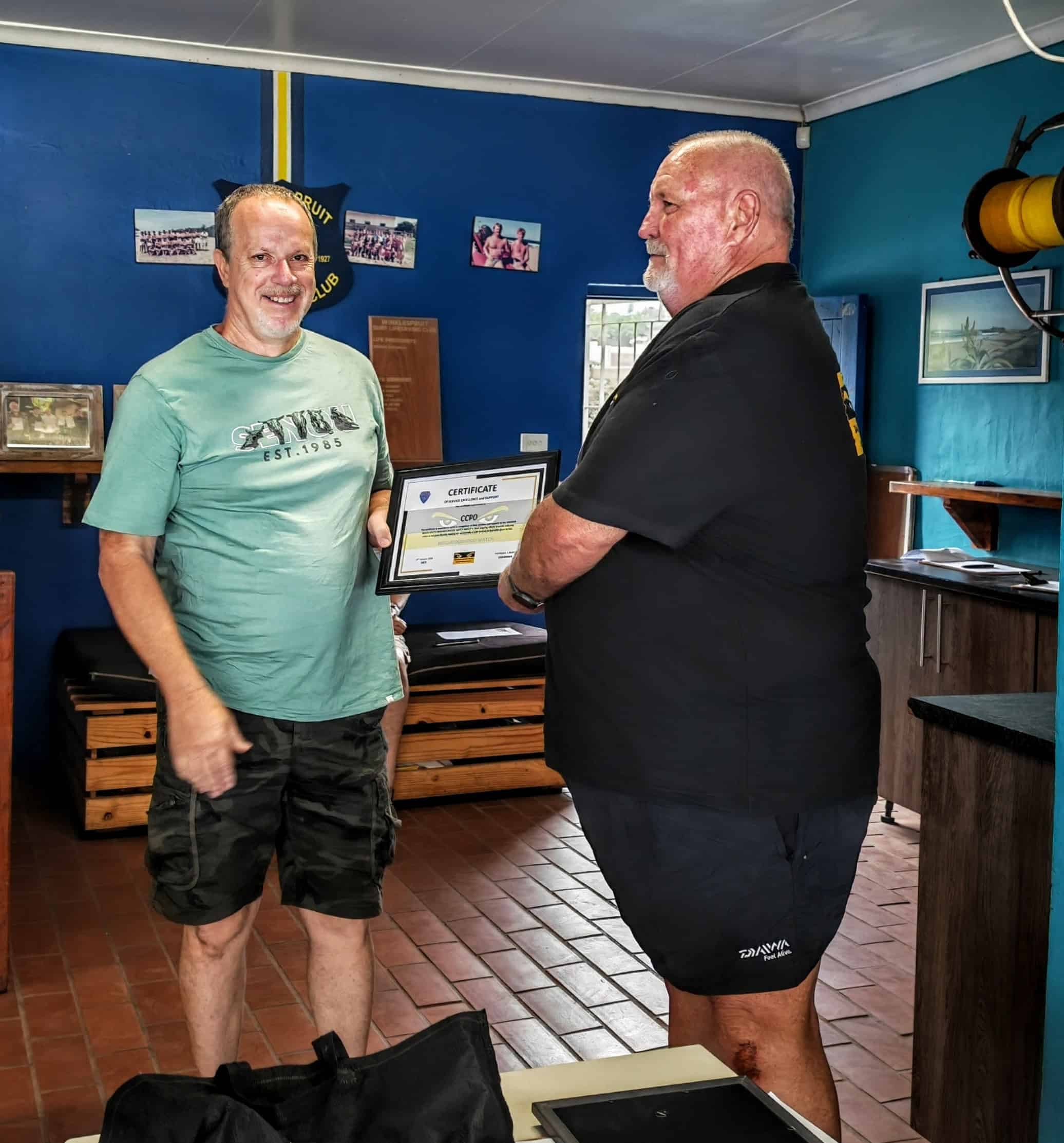 one person handing a certificate to another person