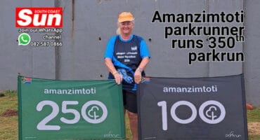 A female runner poses in front of two banners.