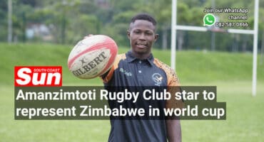 A rugby player on the field holding a rugby ball