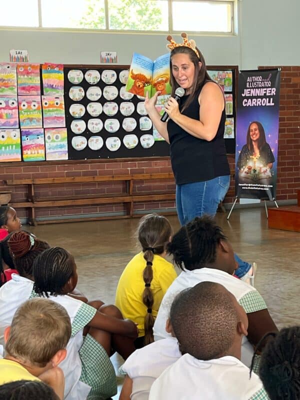a woman reads aloud to school children