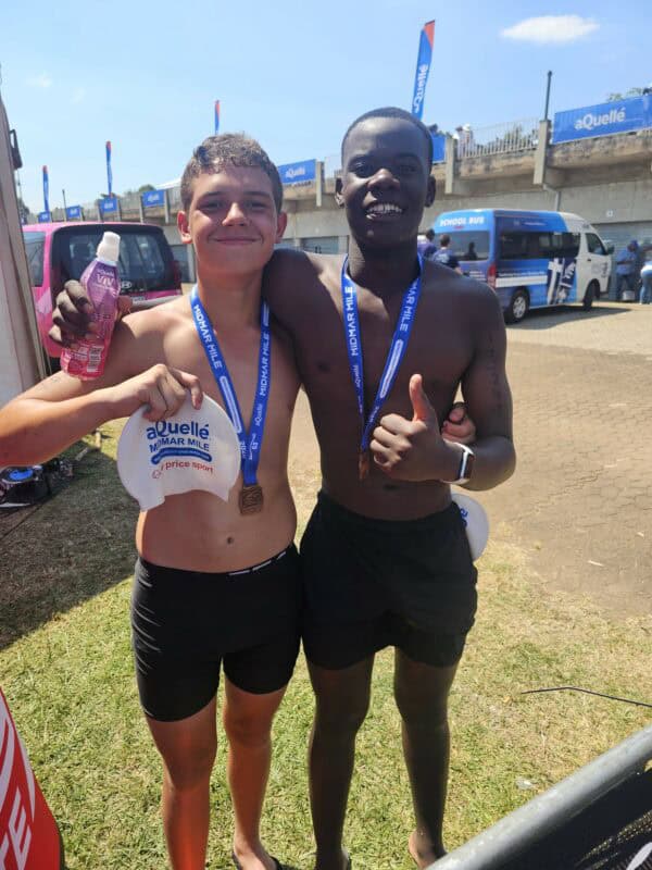two young boys pose for a photo before competing in a swimming race