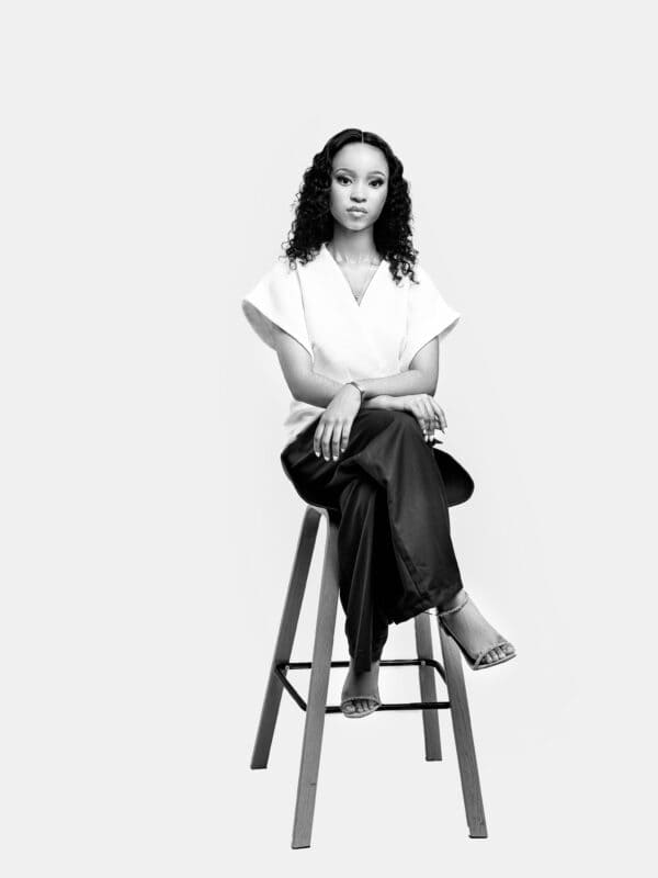 a model sitting on a stool for a portrait