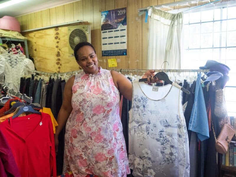 a woman holding a dress on a hanger