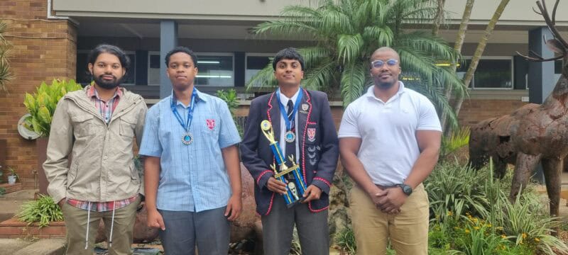 a group of high school learners and teachers with trophies and medals