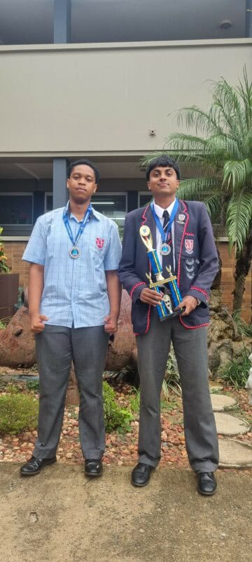 two high school learners with trophies and medals