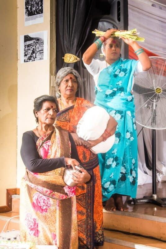 three elderly indian woman acting in a historical sketch
