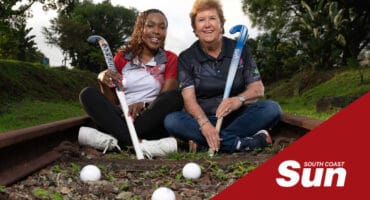 two women with hockey sticks sitting down