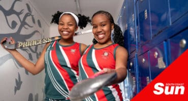 two schoolgirl hockey players in their kits in the locker room