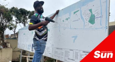 a man with a handheld drill working on a map board