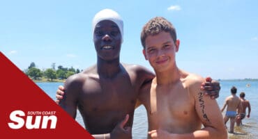two young boys pose for a photo before competing in a swimming race