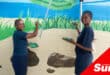 two young artists paint a mural