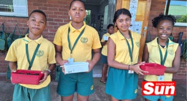 a group photograph of school children doing a natural sciences practical