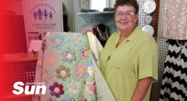 a woman showing an embroided quilt