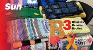 Heaps of knitted blankets on a table.