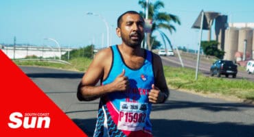 a runner in his athletic kit jogging along the pavement.