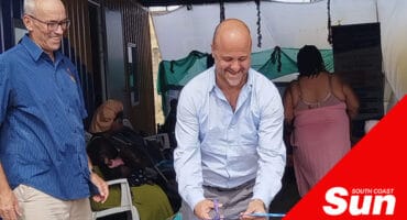 two men cutting a ribbon for a launch