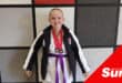 a young girl in her karate kit with a junior purple belt