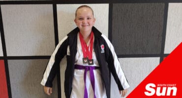 a young girl in her karate kit with a junior purple belt