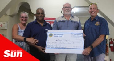 a group photograph of a donation with a large cheque