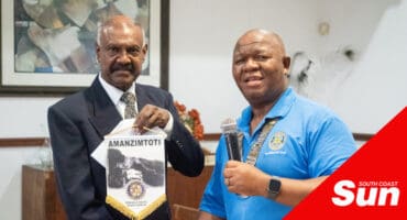 two men, one with a banner and one with a microphone