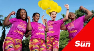 four women in pink holding yellow balloons