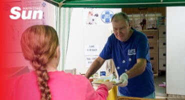 a man serving a customer from his stall