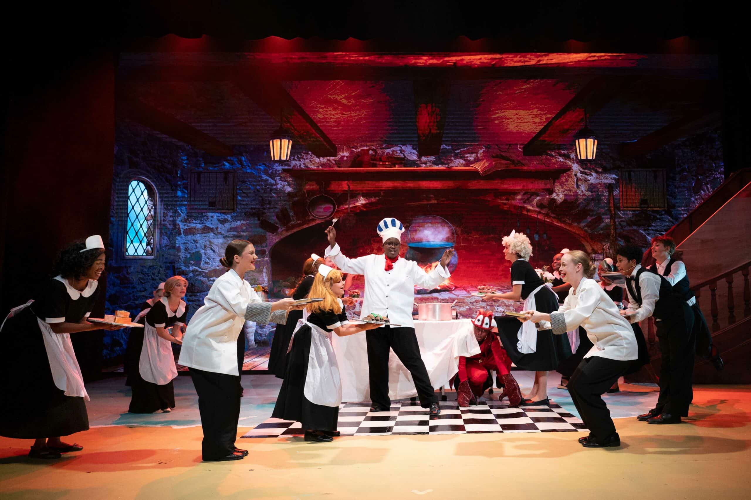a theatre production. the scene is in a kitchen, the chef is dancing