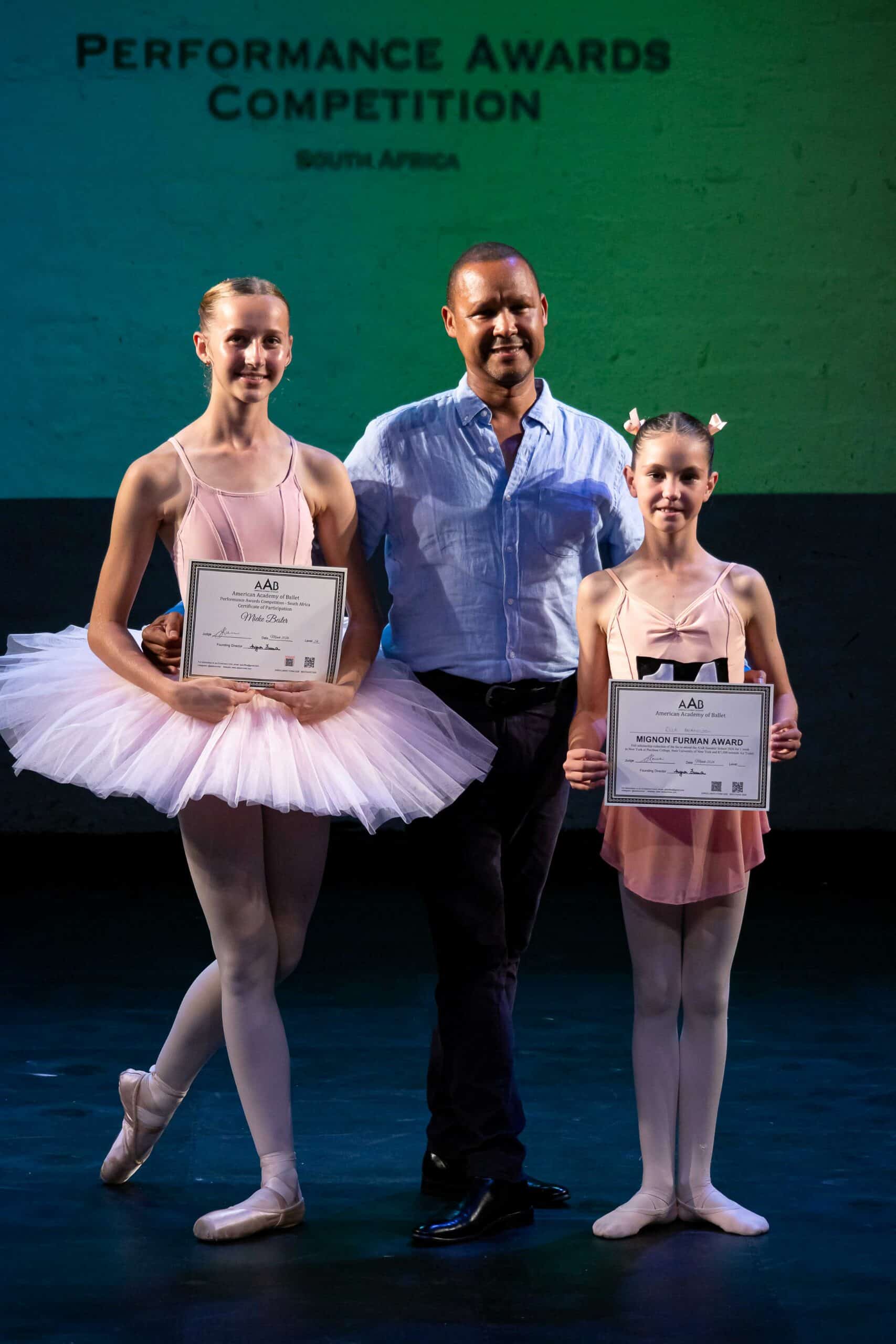a group photograph with a judge and two ballerinas