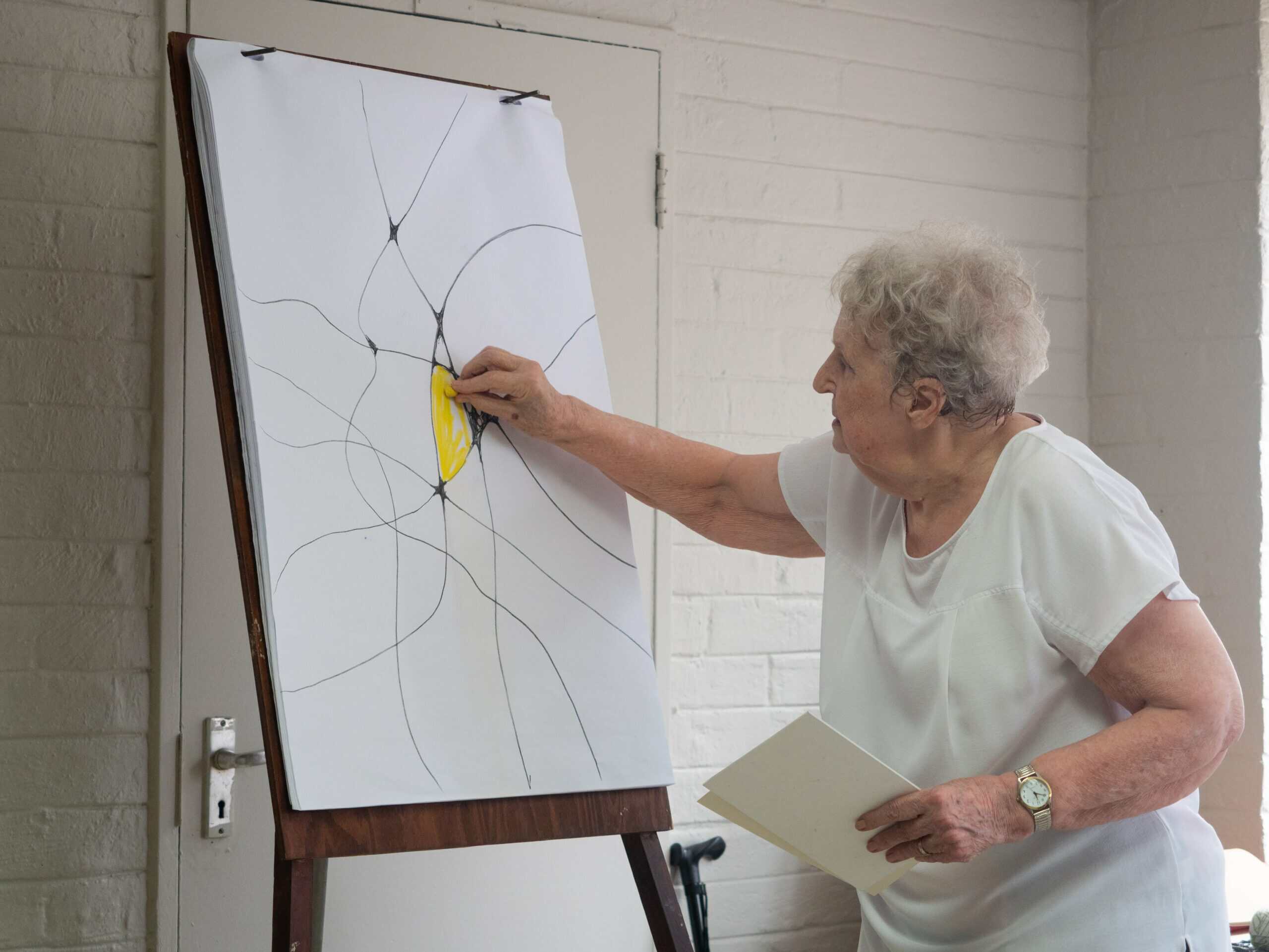 an artist painting with pastel onto a canvas