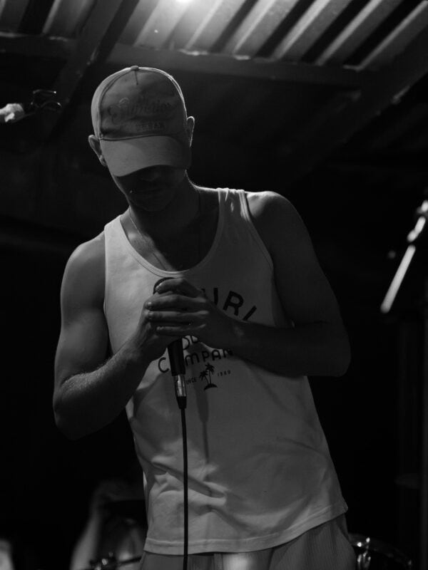 a rapper on stage looking down, holding a mic