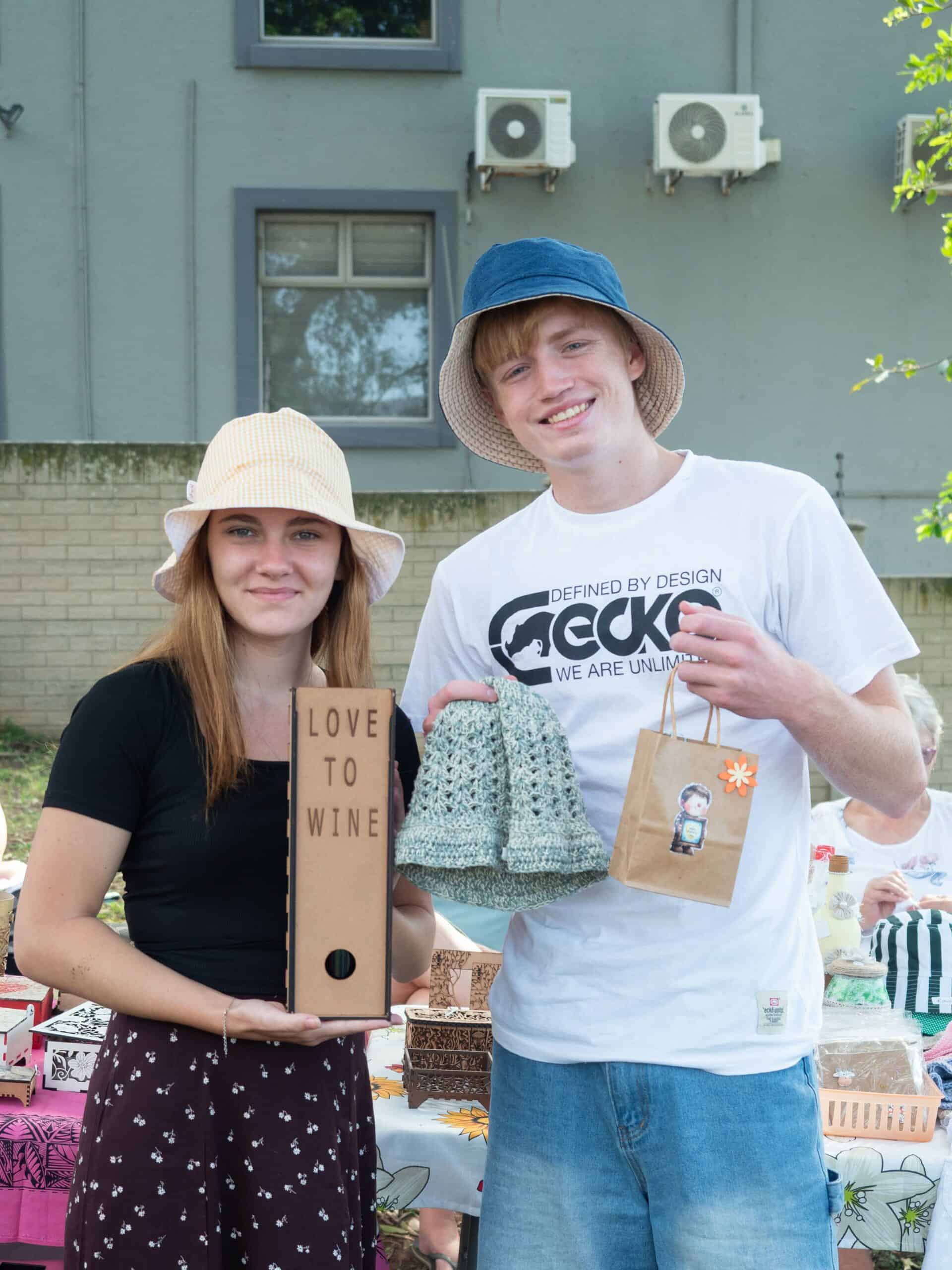 a young man and woman holding artisanal creations