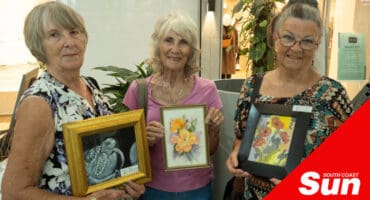 a group of elderly artists showing their paintings