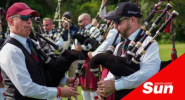 a band of bagpipe players dressed in Highland Games garb, kilts, argyll jackets, sorrans and all.