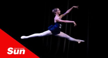 a ballerina performs a grand jeté on stage