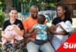 three adults holding three little children and smiling