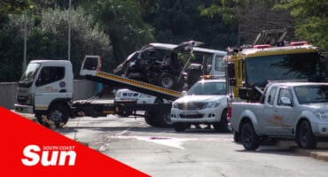 the scene of an accident. a taxi wreckage is being loaded onto a flatbed