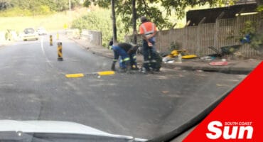 road workers installing a low profile metal speed bump