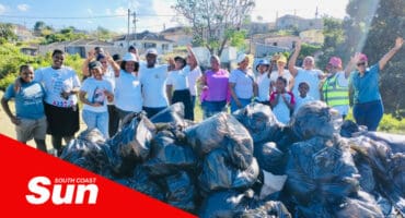 a group photograph with the dozens of rubbish bags in the foreground